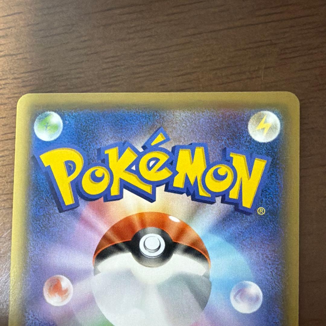 Bastus Black & Darkrai GX trading card with minor wear, displayed on a shelf