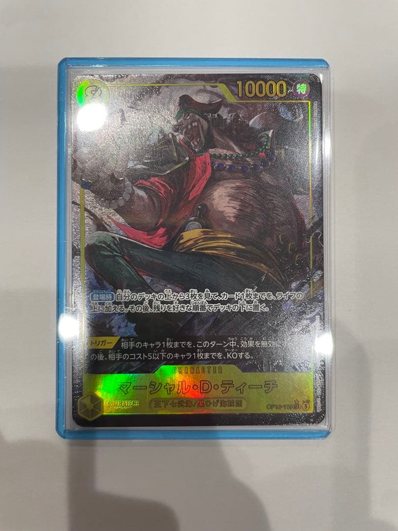 One Piece Marshall D. Teach collectible card in protective sleeve and case showing minor wear