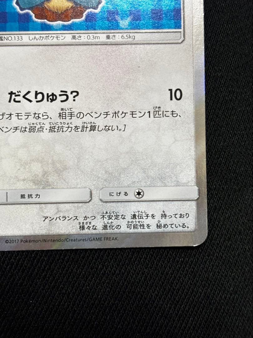 Pokemon promotional card featuring Eevee wearing a poncho with slight crease and small chip