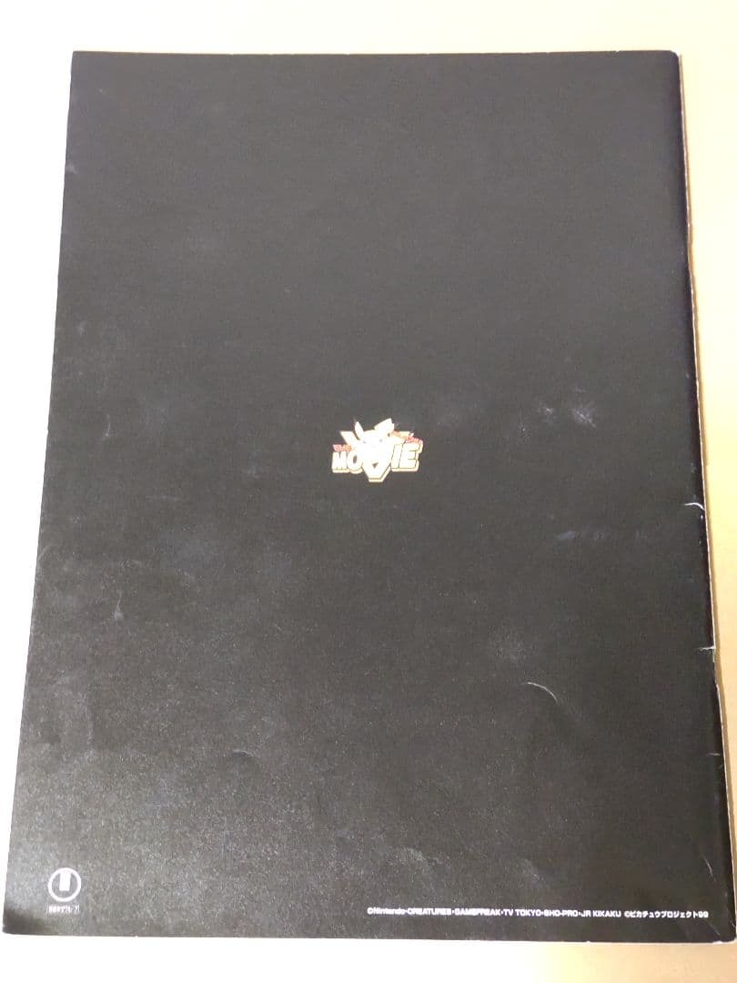 Nintendo Pokemon Ancient Mew first edition card with accompanying movie pamphlet showing wear and stains
