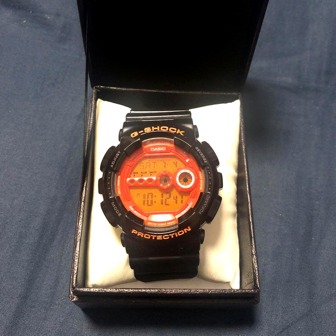 Casio G-Shock watch with black dial, orange accents, and black silicone rubber band