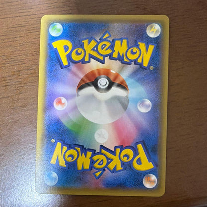 Bastus Black & Darkrai GX trading card with minor wear, displayed on a shelf