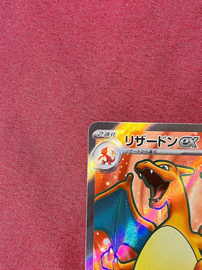 Close-up of Pokemon Charizard EX SV2A SR 185/165 trading card in protective sleeve and rigid loader
