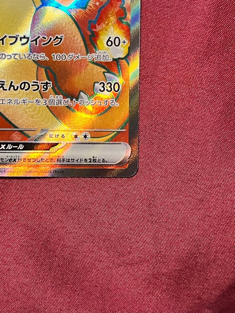Close-up of Pokemon Charizard EX SV2A SR 185/165 trading card in protective sleeve and rigid loader