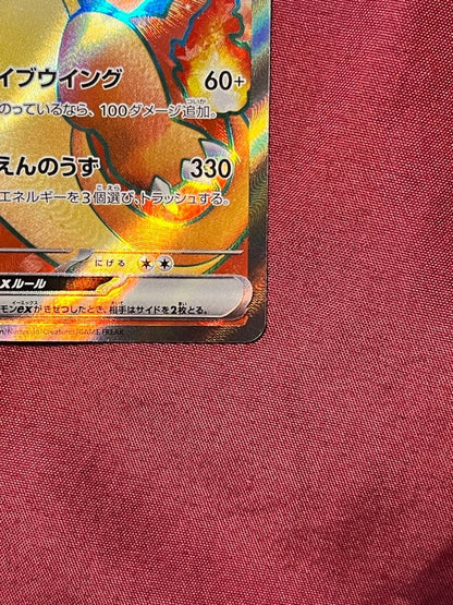 Close-up of Pokemon Charizard EX SV2A SR 185/165 trading card in protective sleeve and rigid loader