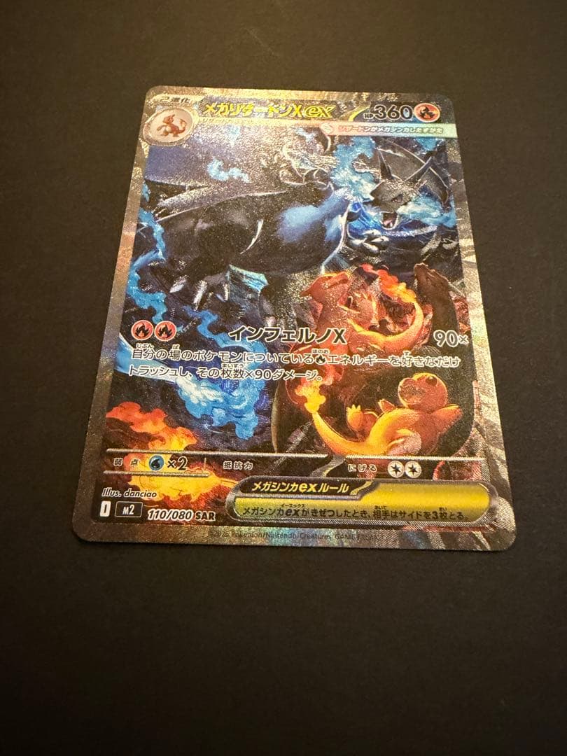 Bandai Mega Charizard X X SAR 110/080 collectible card showing black Charizard, Charmander, and Charmeleon from Japan