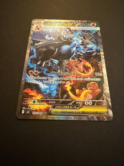 Bandai Mega Charizard X X SAR 110/080 collectible card showing black Charizard, Charmander, and Charmeleon from Japan