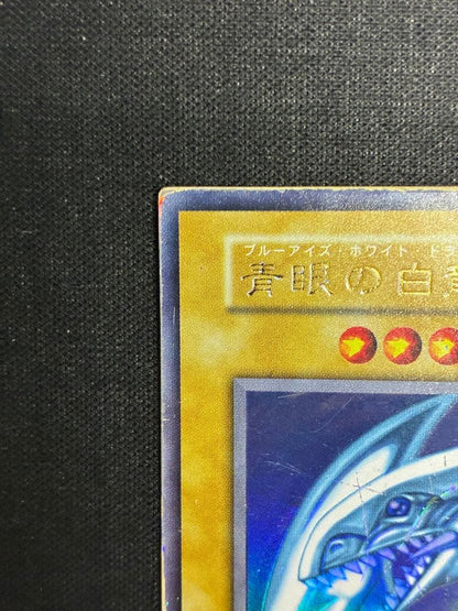 Blue-Eyes White Dragon Yu-Gi-Oh! trading card in early condition with visible signs of use