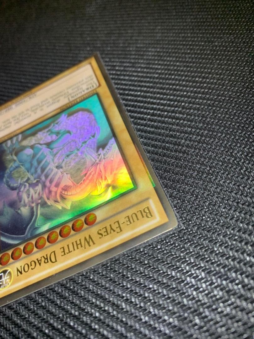 Blue Eyes White Dragon Ghost Rare hologram error Yu-Gi-Oh card with edge-overlapping hologram in protective sleeve