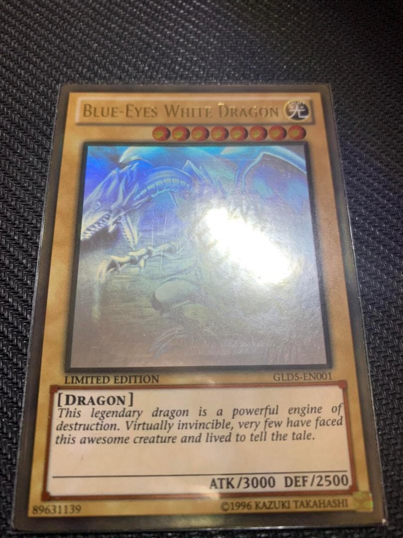 Blue Eyes White Dragon Ghost Rare hologram error Yu-Gi-Oh card with edge-overlapping hologram in protective sleeve