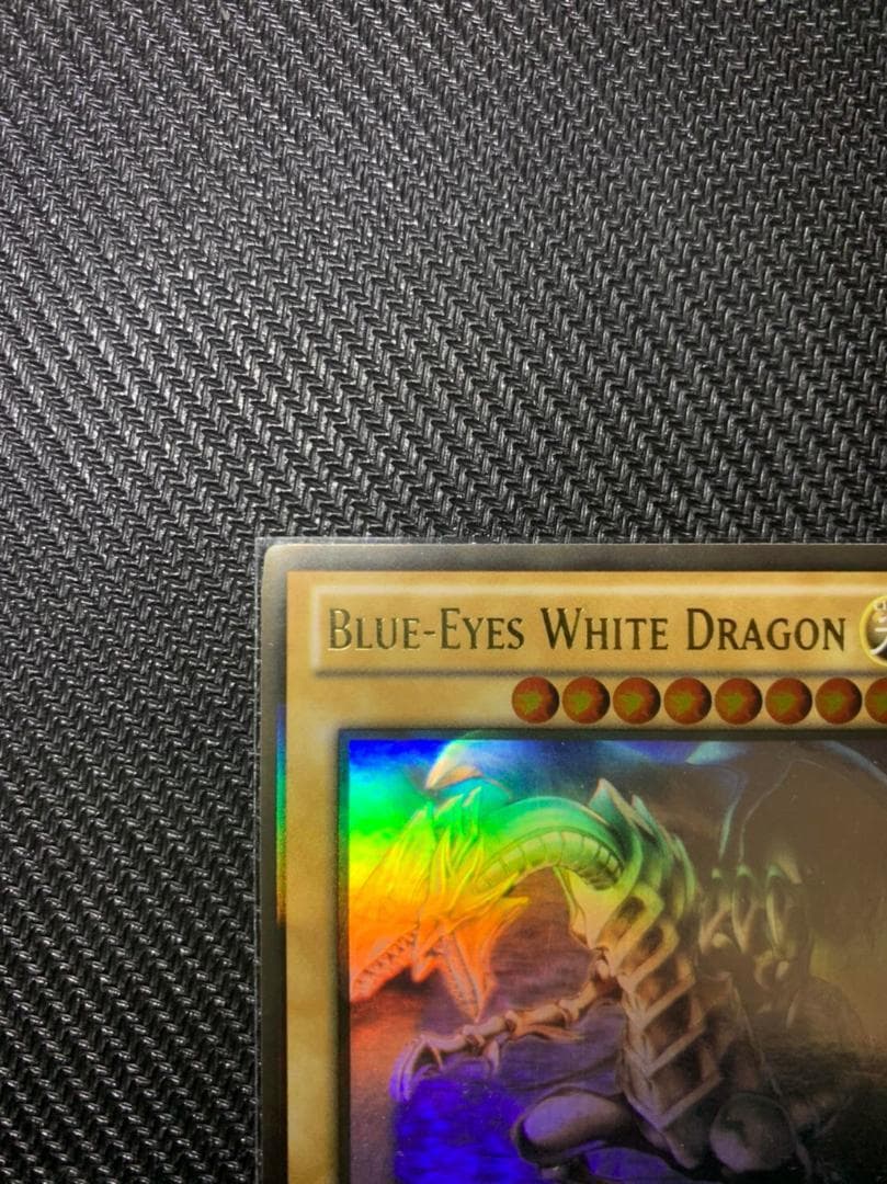 Blue Eyes White Dragon Ghost Rare hologram error Yu-Gi-Oh card with edge-overlapping hologram in protective sleeve
