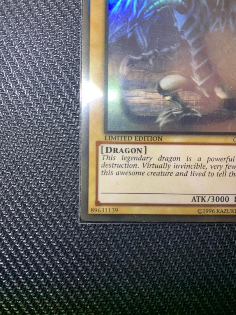 Blue Eyes White Dragon Ghost Rare hologram error Yu-Gi-Oh card with edge-overlapping hologram in protective sleeve
