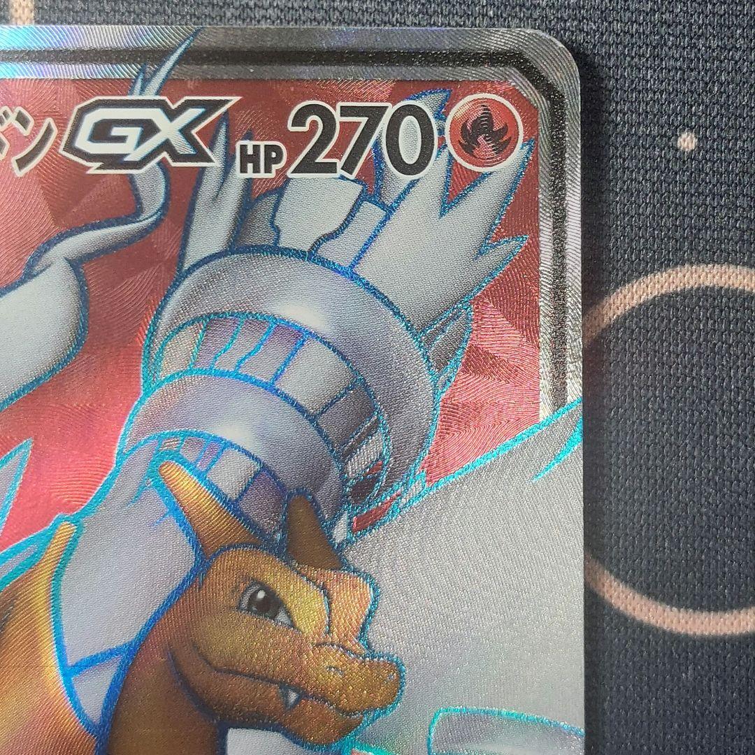 Pokemon trading card Reshiram & Charizard GX SR from Tag Team GX series with visible white scratches