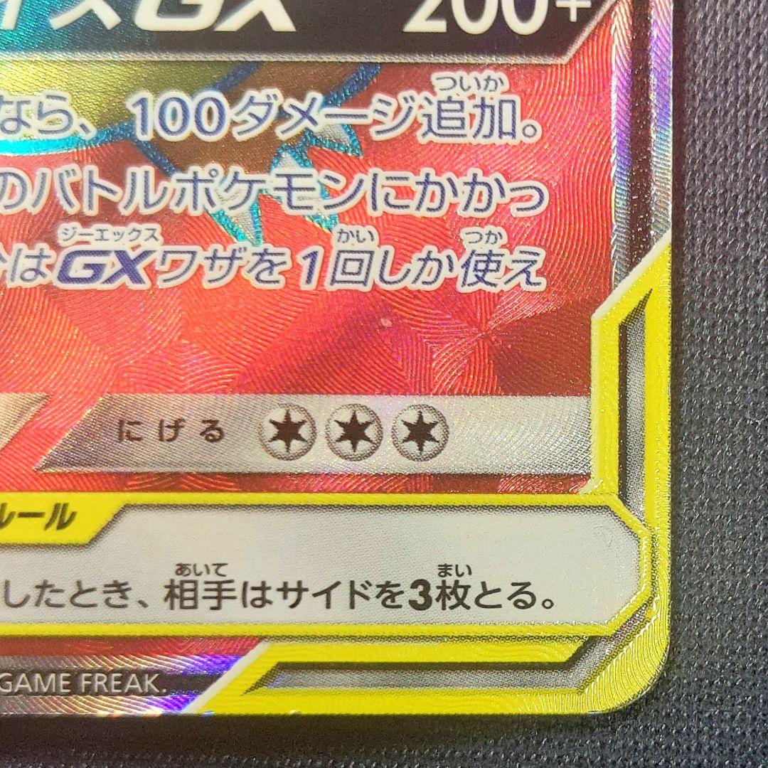 Pokemon trading card Reshiram & Charizard GX SR from Tag Team GX series with visible white scratches