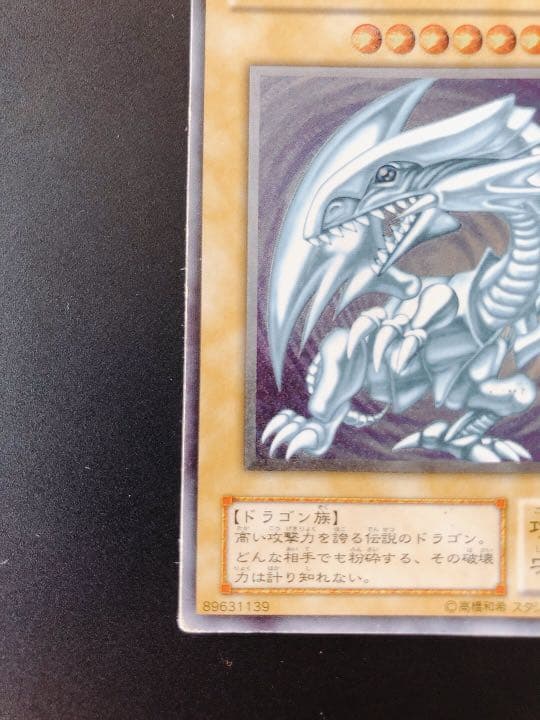 Yugioh Blue-Eyes White Dragon Relief trading card with visible scratches from over 20 years ago