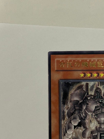 Antique Gear Golem Ultimate Rare Yu-Gi-Oh! card with worn edges and visible horizontal line on back