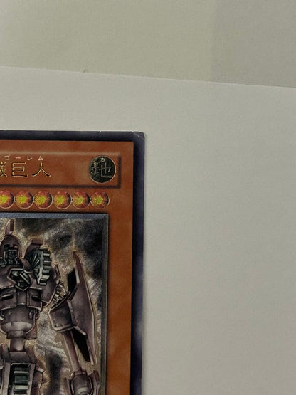 Antique Gear Golem Ultimate Rare Yu-Gi-Oh! card with worn edges and visible horizontal line on back