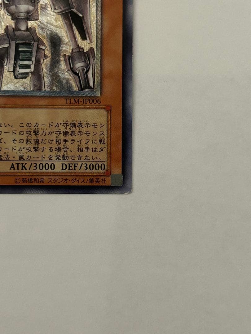 Antique Gear Golem Ultimate Rare Yu-Gi-Oh! card with worn edges and visible horizontal line on back