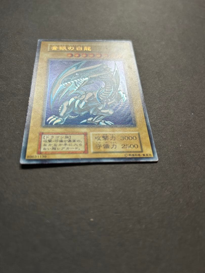 Blue-Eyes White Dragon Ultra Rare Yu-Gi-Oh! OCG card from starter box with visible wear