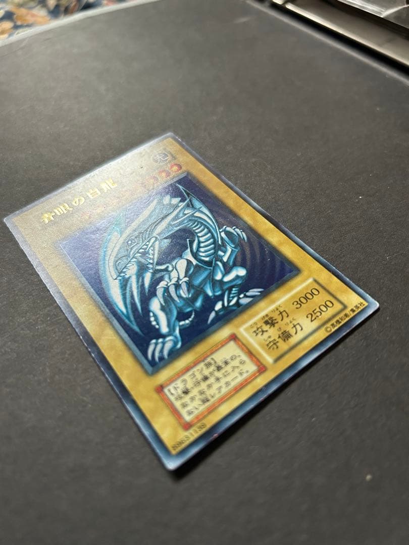 Blue-Eyes White Dragon Ultra Rare Yu-Gi-Oh! OCG card from starter box with visible wear