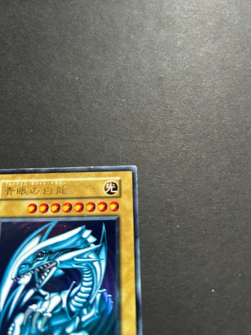 Blue-Eyes White Dragon Ultra Rare Yu-Gi-Oh! OCG card from starter box with visible wear