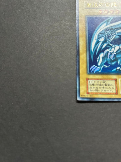 Blue-Eyes White Dragon Ultra Rare Yu-Gi-Oh! OCG card from starter box with visible wear