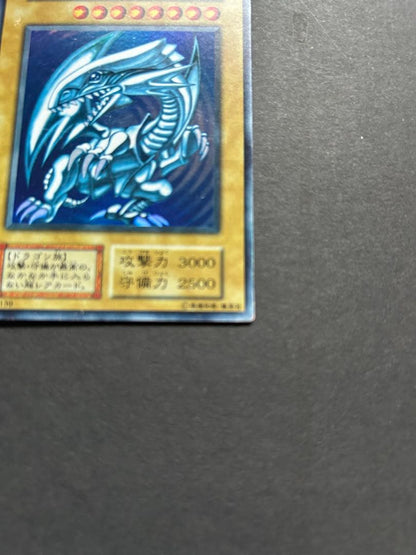 Blue-Eyes White Dragon Ultra Rare Yu-Gi-Oh! OCG card from starter box with visible wear