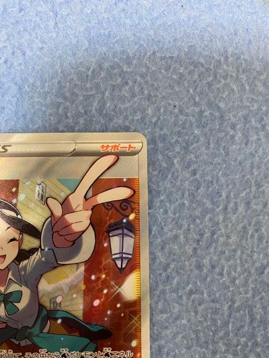 Unopened Suzuna SR Pokémon card sleeved and displayed in a hard loader