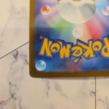 Yu Nagaba Nymphia Pokémon promotional card with minor scratches and protective sleeve