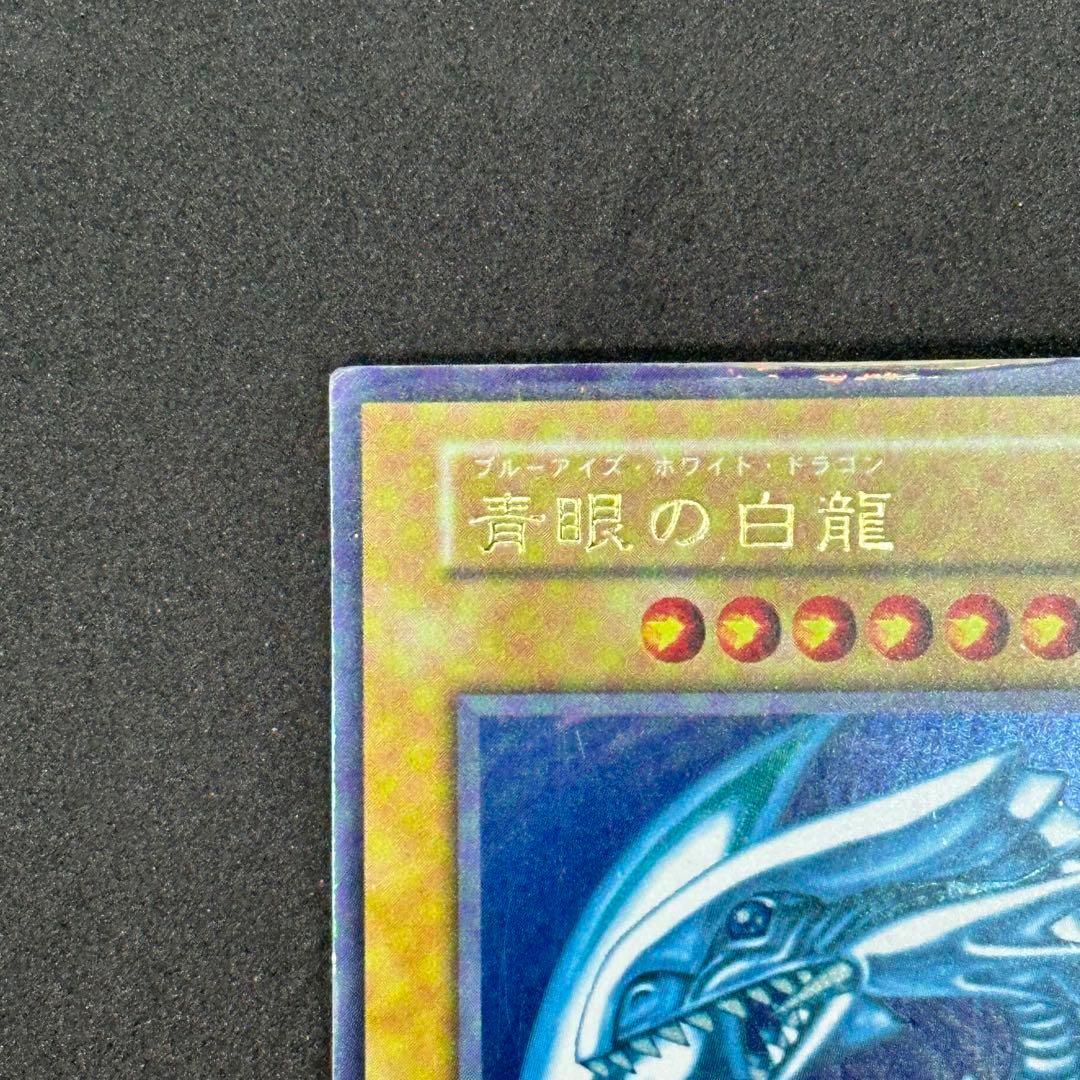 Yu-Gi-Oh! Blue-Eyes White Dragon Ultra Rare First Edition monster card with slight tear on top edge