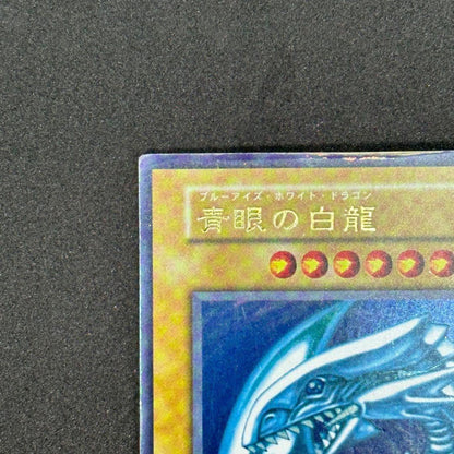 Yu-Gi-Oh! Blue-Eyes White Dragon Ultra Rare First Edition monster card with slight tear on top edge