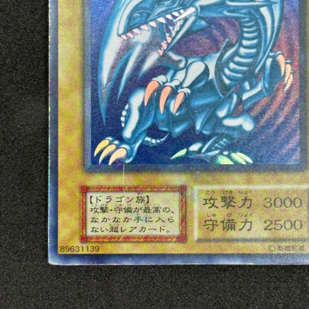 Yu-Gi-Oh! Blue-Eyes White Dragon Ultra Rare First Edition monster card with slight tear on top edge