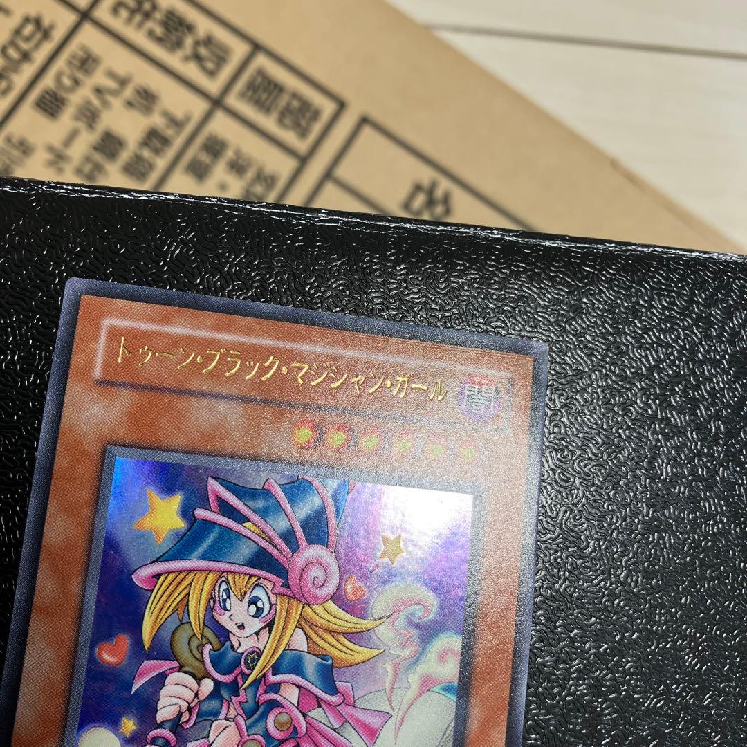 Bandai Toon Black Magician Girl Ultra Rare trading card showing visible wear, dents, creases, and chips