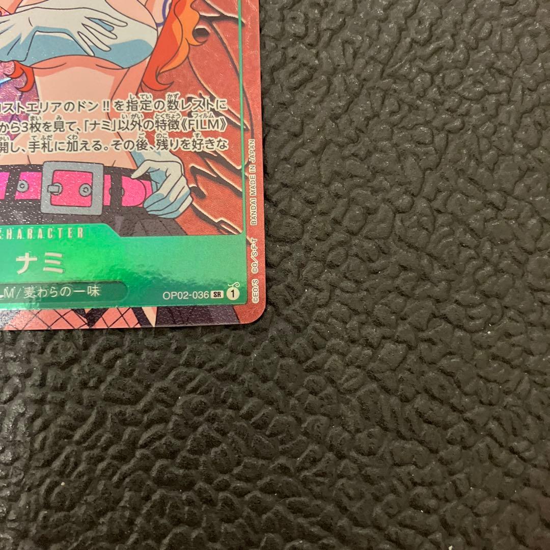 One Piece Nami SR Parallel card OP02-036 showing front design with visible wear and corner chip