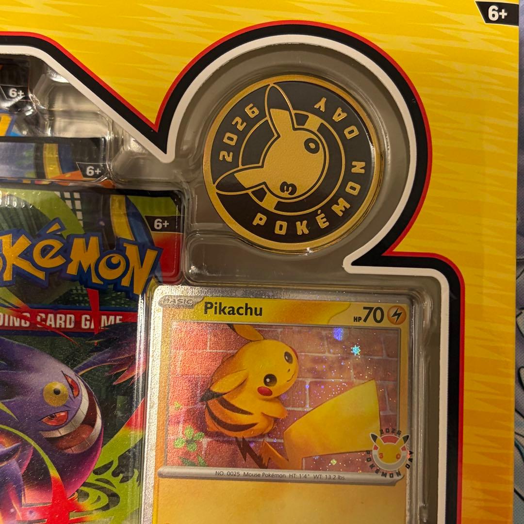 Pokemon Day 2026 Collection English version box with Pikachu promo card, coin, and three booster packs