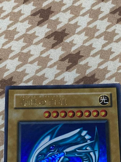 Blue-Eyes White Dragon 2nd Edition trading card with misaligned eyes error, used condition