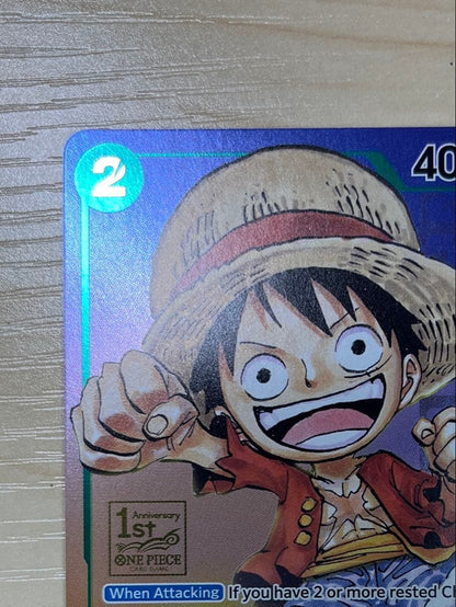 One Piece Monster D. Luffy 1st Anniversary Promo English version card with visible surface wear and white fade on the back