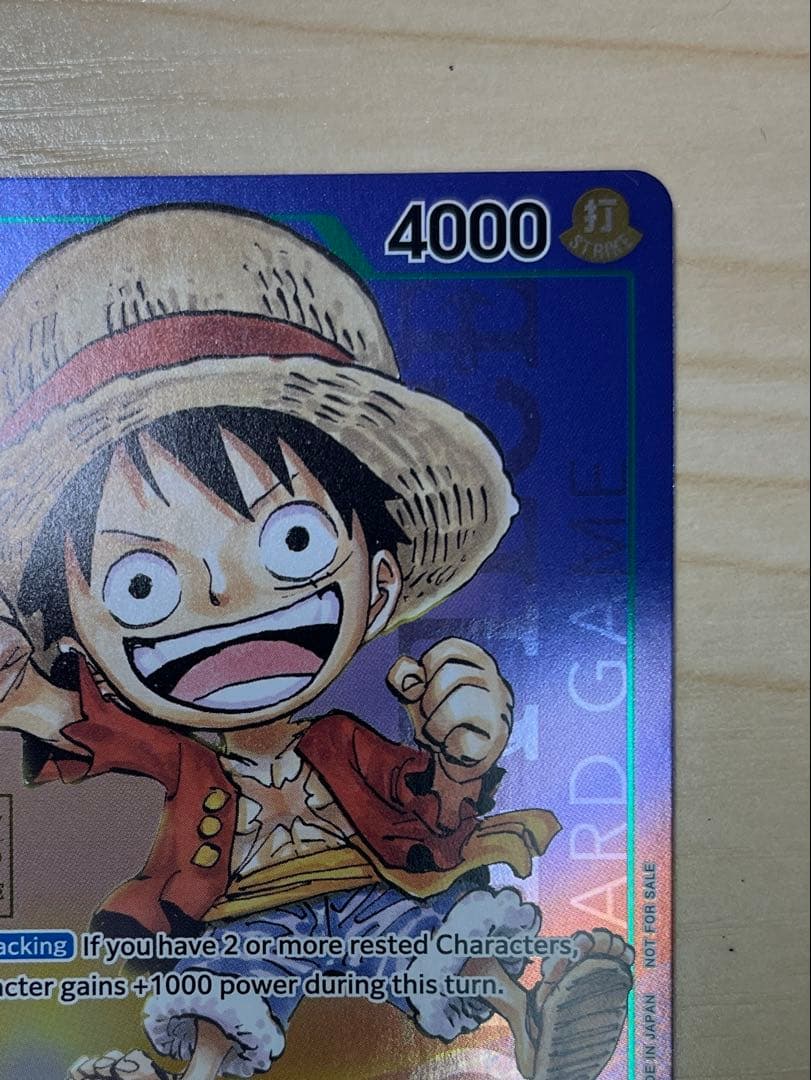 One Piece Monster D. Luffy 1st Anniversary Promo English version card with visible surface wear and white fade on the back