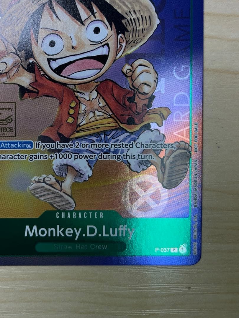 One Piece Monster D. Luffy 1st Anniversary Promo English version card with visible surface wear and white fade on the back