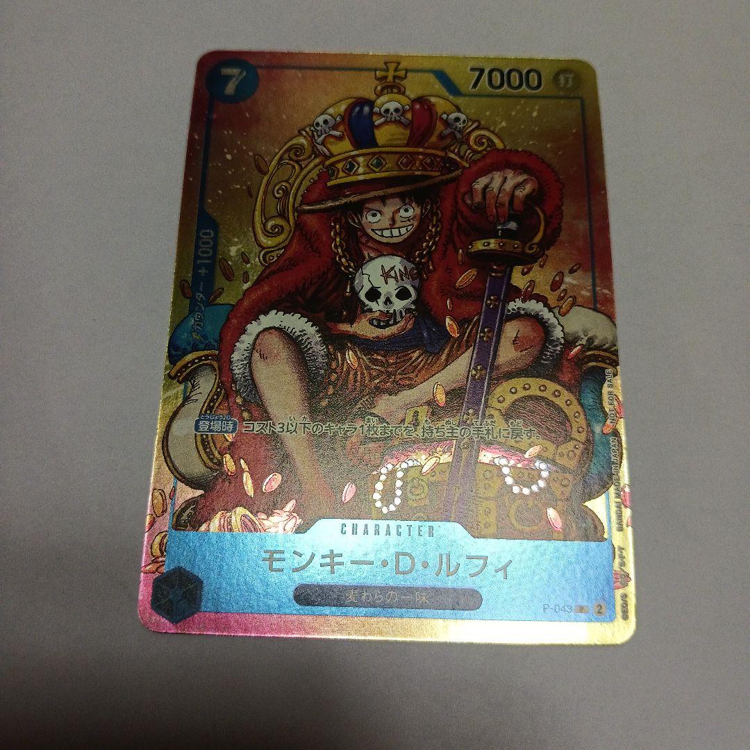 One Piece Monkey D. Luffy P-043 card showing Luffy wearing a crown sitting in a treasure chest