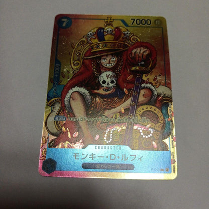 One Piece Monkey D. Luffy P-043 card showing Luffy wearing a crown sitting in a treasure chest