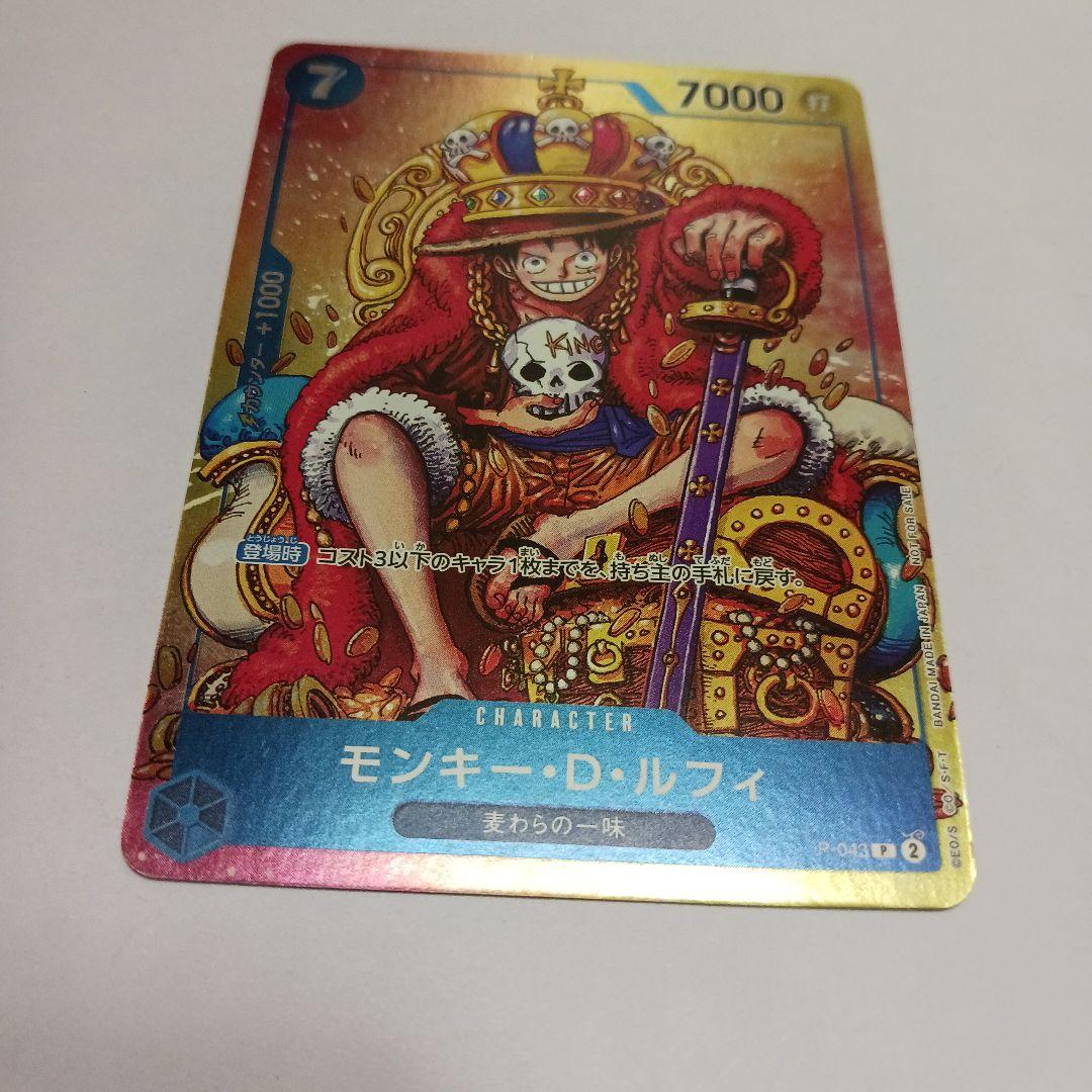 One Piece Monkey D. Luffy P-043 card showing Luffy wearing a crown sitting in a treasure chest