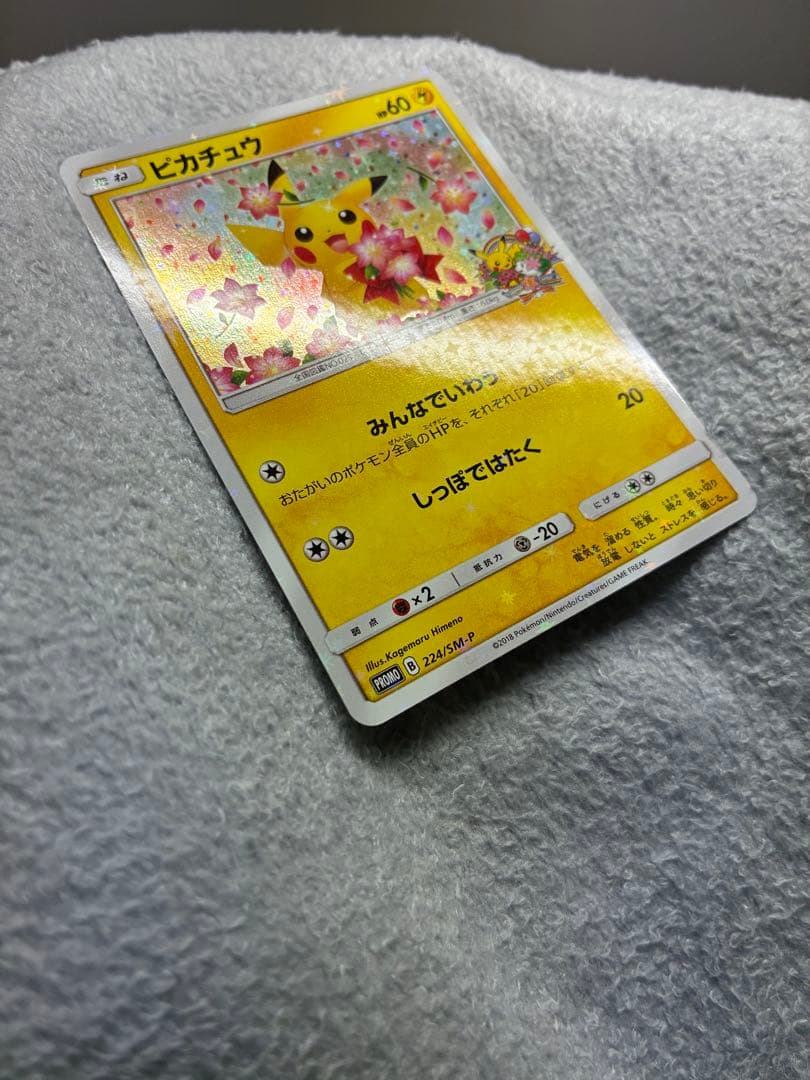 Pokemon Center 20th Anniversary Pikachu promotional card 224/SM-P in protective sleeve with loader and cardboard support