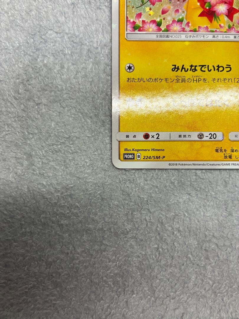 Pokemon Center 20th Anniversary Pikachu promotional card 224/SM-P in protective sleeve with loader and cardboard support