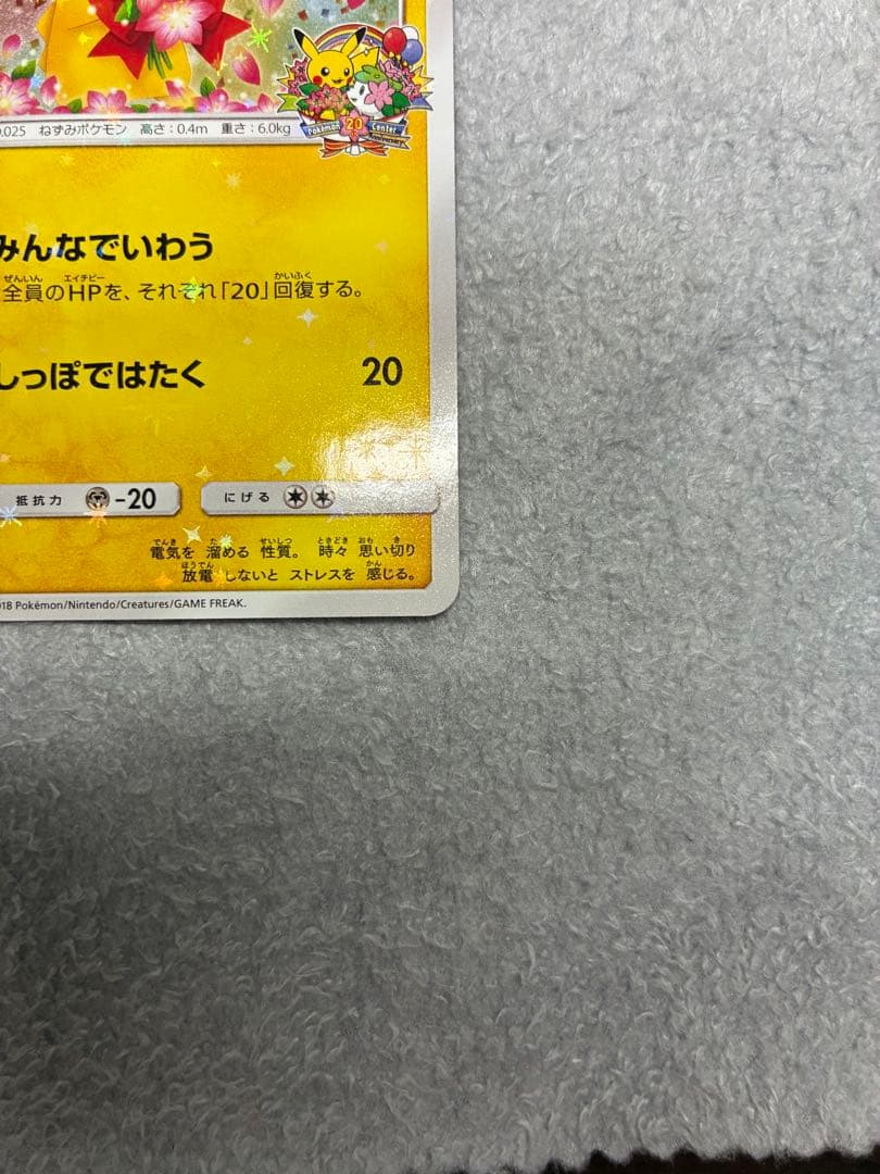 Pokemon Center 20th Anniversary Pikachu promotional card 224/SM-P in protective sleeve with loader and cardboard support