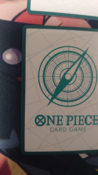 One Piece Card Game cards featuring Sabo, Luffy, Uta, and Akainu with gold borders in protective sleeve
