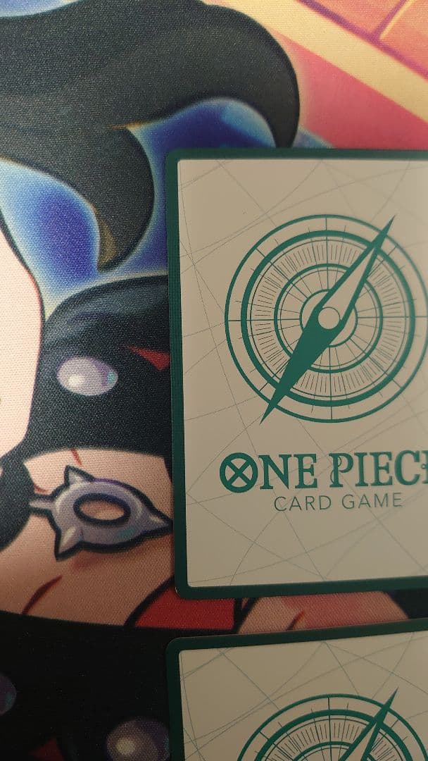 One Piece Card Game cards featuring Sabo, Luffy, Uta, and Akainu with gold borders in protective sleeve