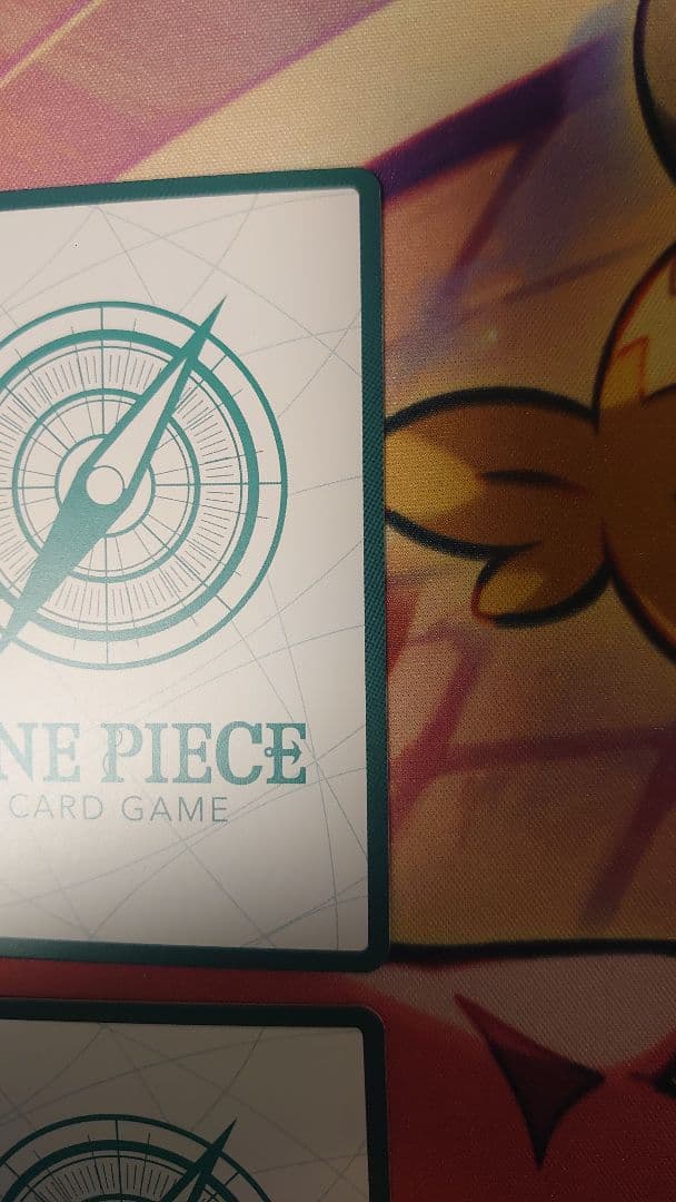 One Piece Card Game cards featuring Sabo, Luffy, Uta, and Akainu with gold borders in protective sleeve