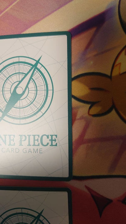 One Piece Card Game cards featuring Sabo, Luffy, Uta, and Akainu with gold borders in protective sleeve
