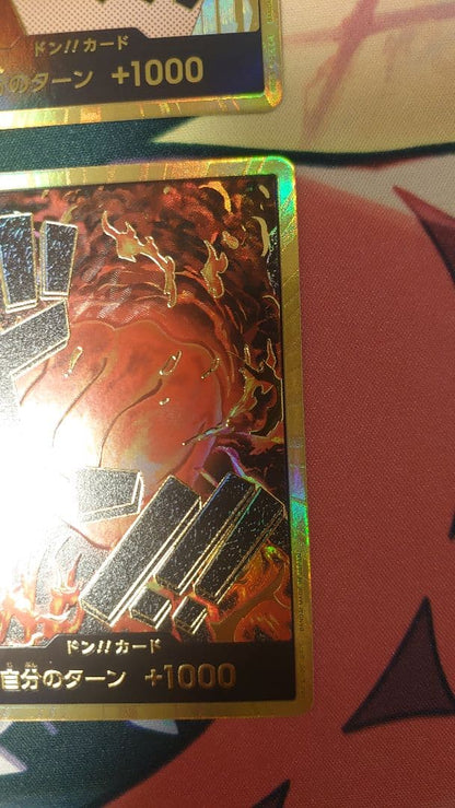 One Piece Card Game cards featuring Sabo, Luffy, Uta, and Akainu with gold borders in protective sleeve